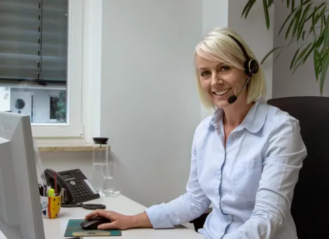 Bürokauffrau mit Headset in einem SHK-Handwerksbetrieb.