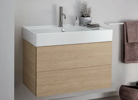 Kompaktes Stocco Badmöbel mit heller Holzoptik, integriertem Waschbecken und weichen Textilakzenten.