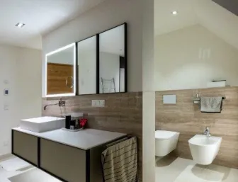 Modernes Badezimmer mit Waschtisch, wandhängendem WC und Bidet in heller, minimalistischer Gestaltung.
