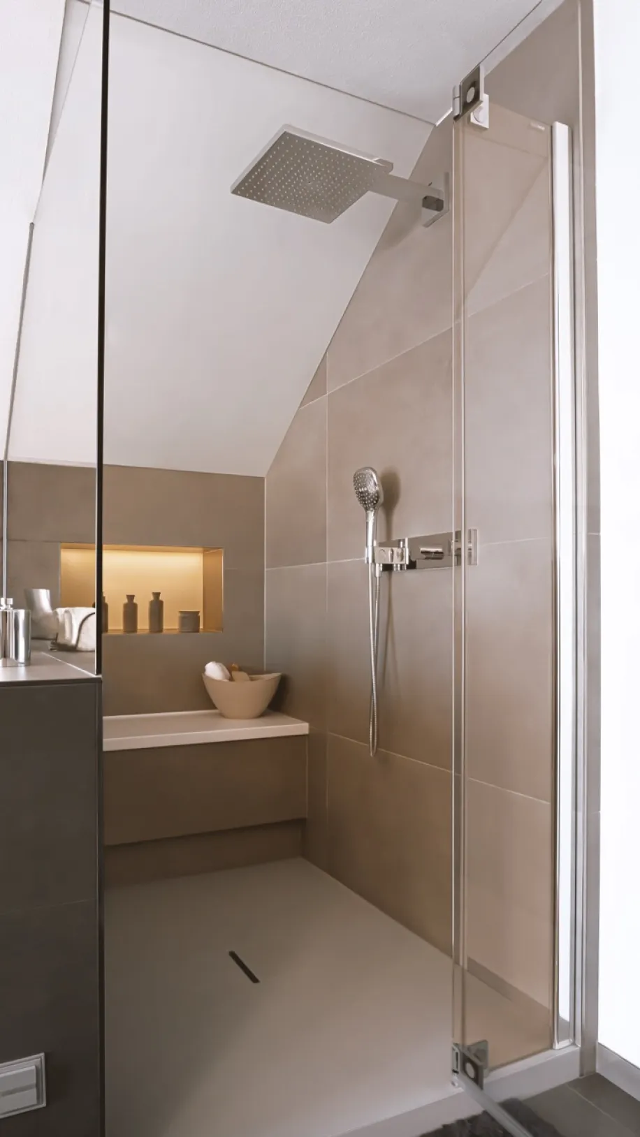 Moderne Walk-in-Dusche unter Dachschräge mit Regendusche, Glasabtrennung und integrierter beleuchteter Ablagenische.