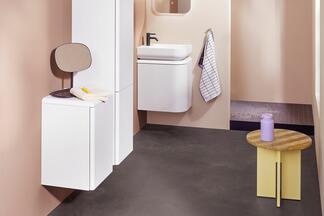 Badezimmer mit weißen Designmöbeln und gelben Hocker